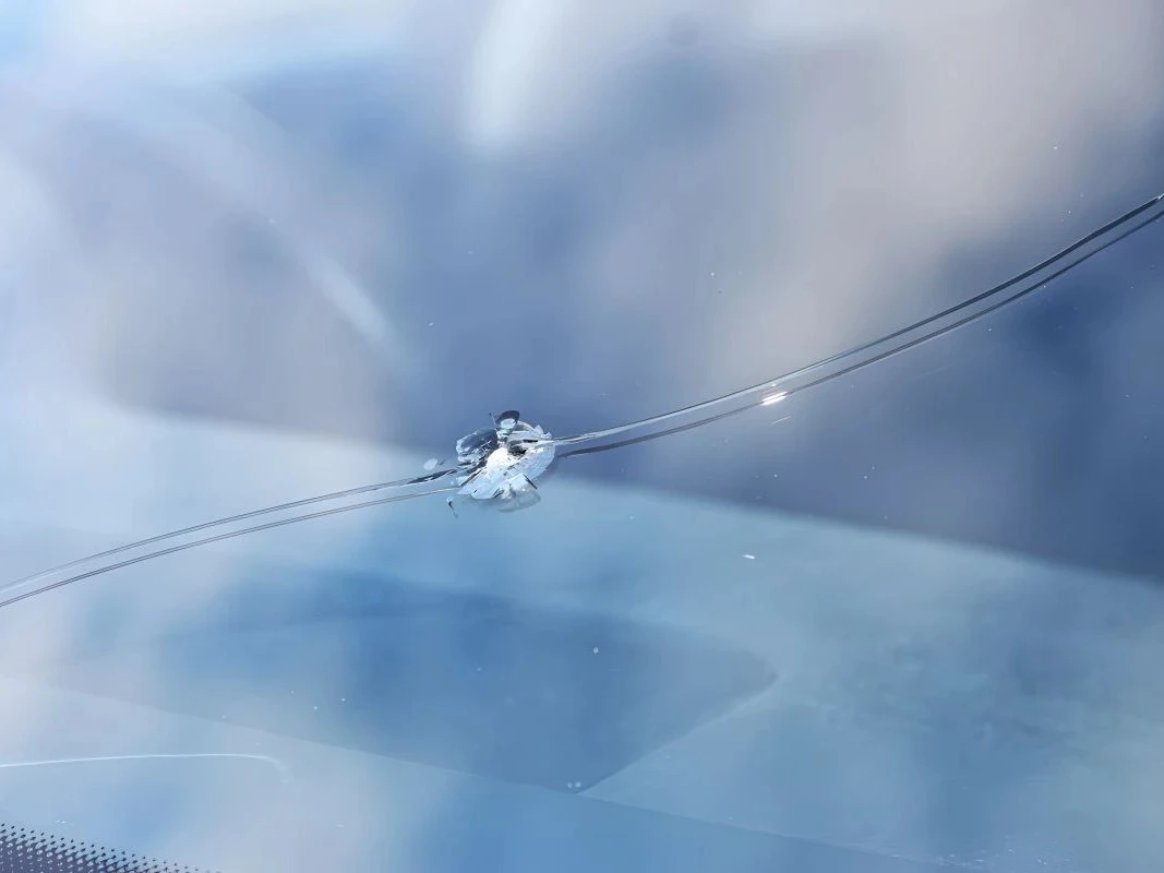 Közelkép egy elrepedt szélvédőről, amely már akadályozza a biztonságos kilátást.